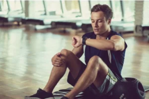 Man checking fitness tracker at gym